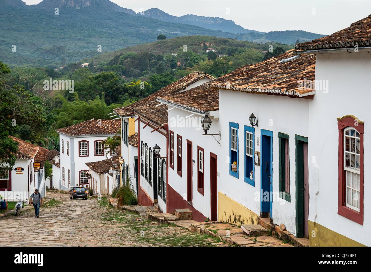 Fachada de muchas coloridas casas coloniales situadas en la calle adoquinada Rua da Camara en el centro histórico Tiradentes bajo el cielo nublado. Foto de stock