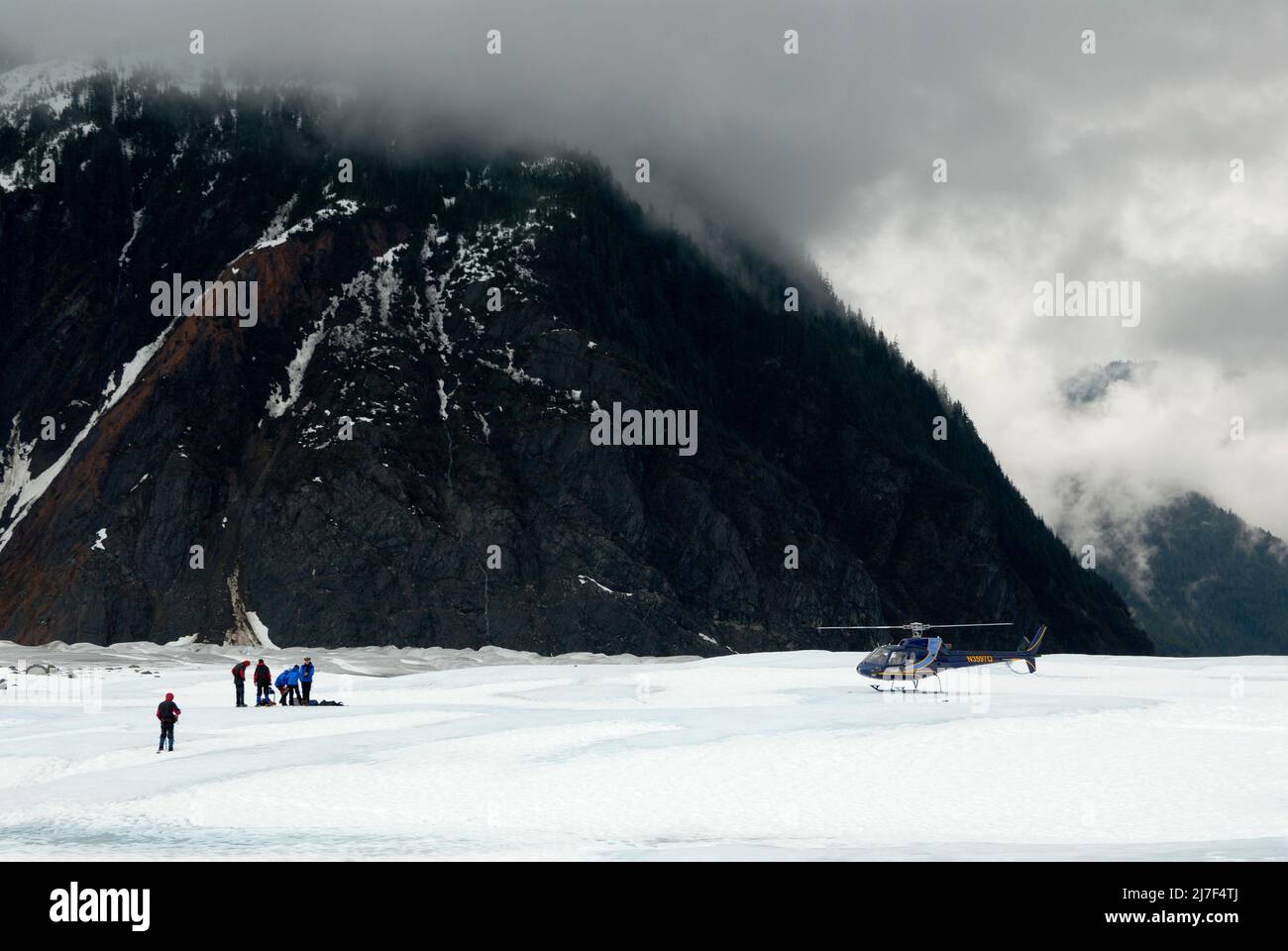 Los turistas y su helicóptero de transporte en el glaciar Mendenhall, cerca de Juneau. Foto de stock