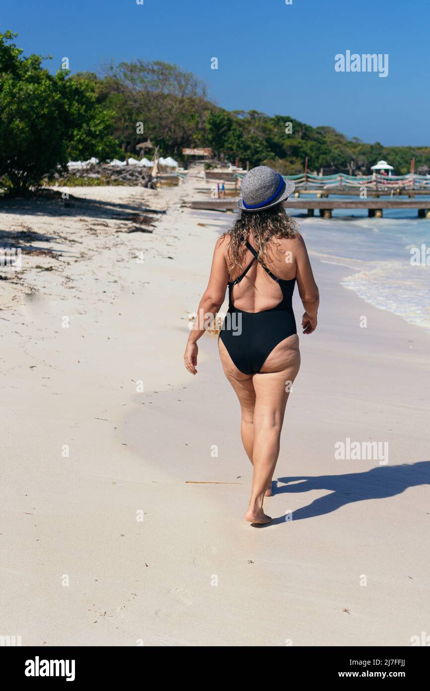 Mujer madura en su espalda caminando en la playa Fotografía de stock - Alamy