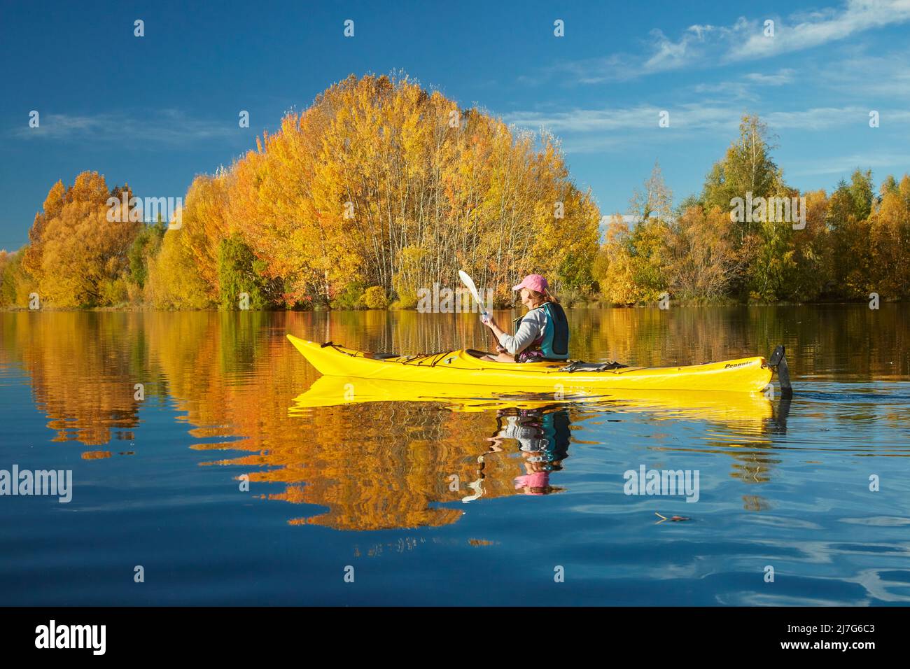 Kayak y reflexiones otoñales en Kellands Pond, cerca de Twizel, Mackenzie District, North Otago, South Island, Nueva Zelanda (lanzamiento del modelo) Foto de stock