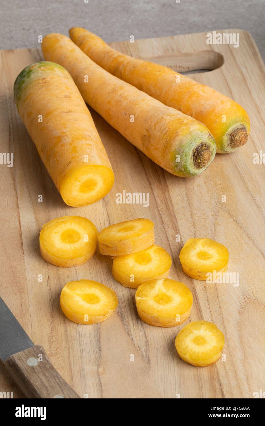 Zanahorias amarillas y rodajas en una tabla de corte de cerca Foto de stock