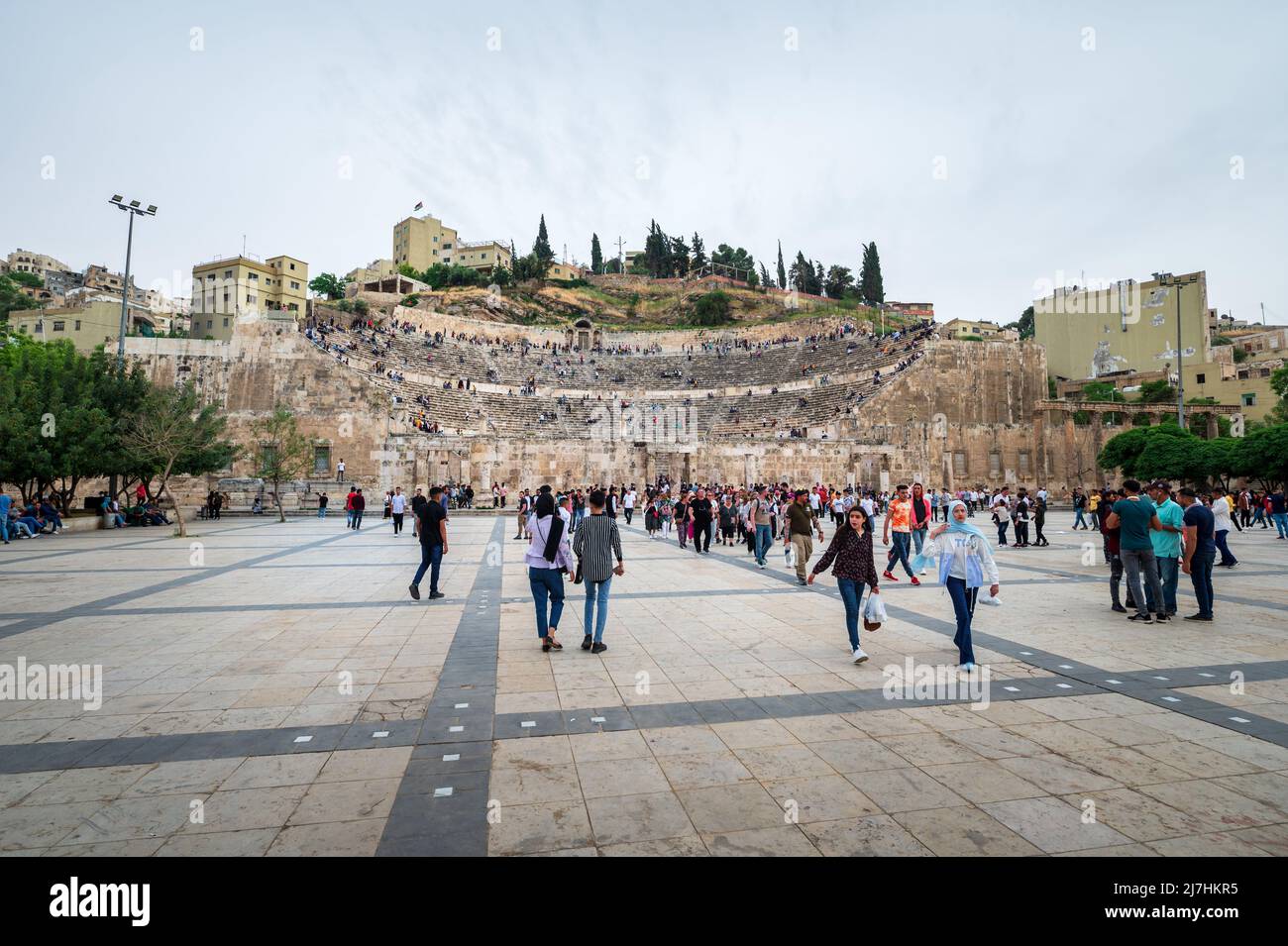 Amman, Jordania - 2 de mayo de 2022: Gente reuniéndose en el centro de Amman frente a la antigua estructura del teatro romano para celebrar las vacaciones de los musulmanes Eid entre los resi Foto de stock