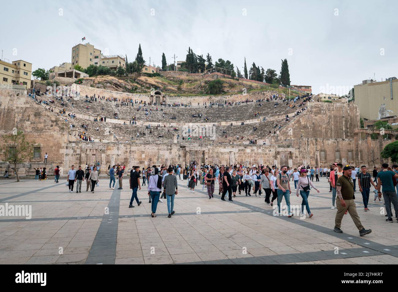 Amman, Jordania - 2 de mayo de 2022: Gente reuniéndose en el centro de Amman frente a la antigua estructura del teatro romano para celebrar las vacaciones de los musulmanes Eid entre los resi Foto de stock