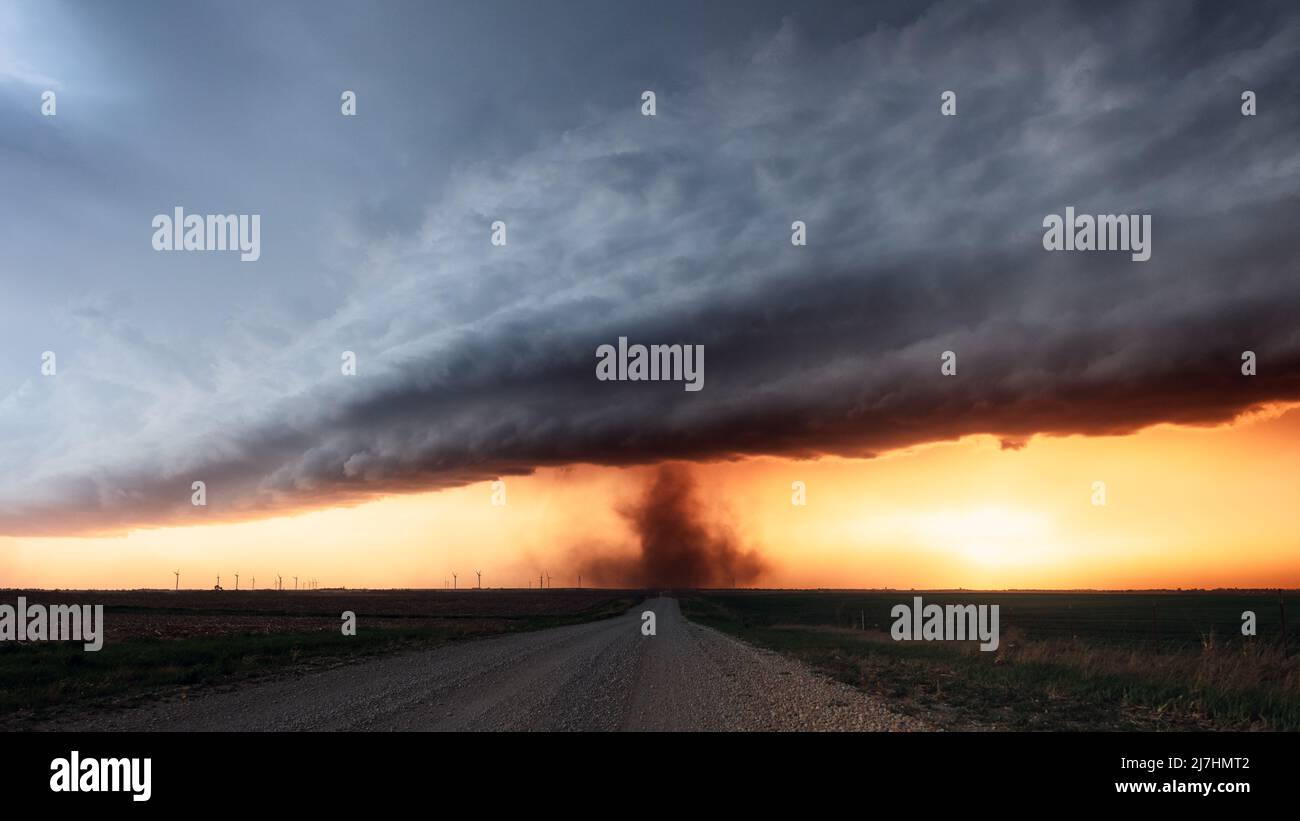 Un tornado de descarga terrestre gira bajo las espectaculares nubes de tormenta al atardecer cerca de Herington, Kansas Foto de stock