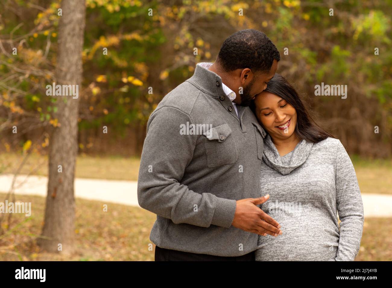 Pareja Embarazada Caminando y sosteniendo las manos en el parque Foto de stock