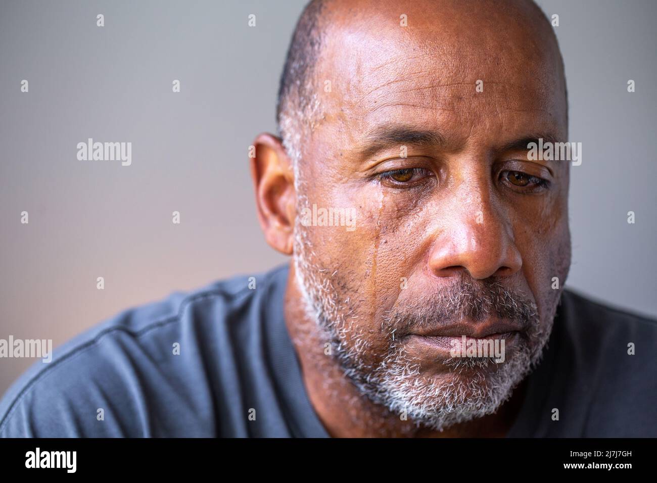 Retrato de un hombre maduro que se ve triste con lágrimas en sus ojos. Foto de stock