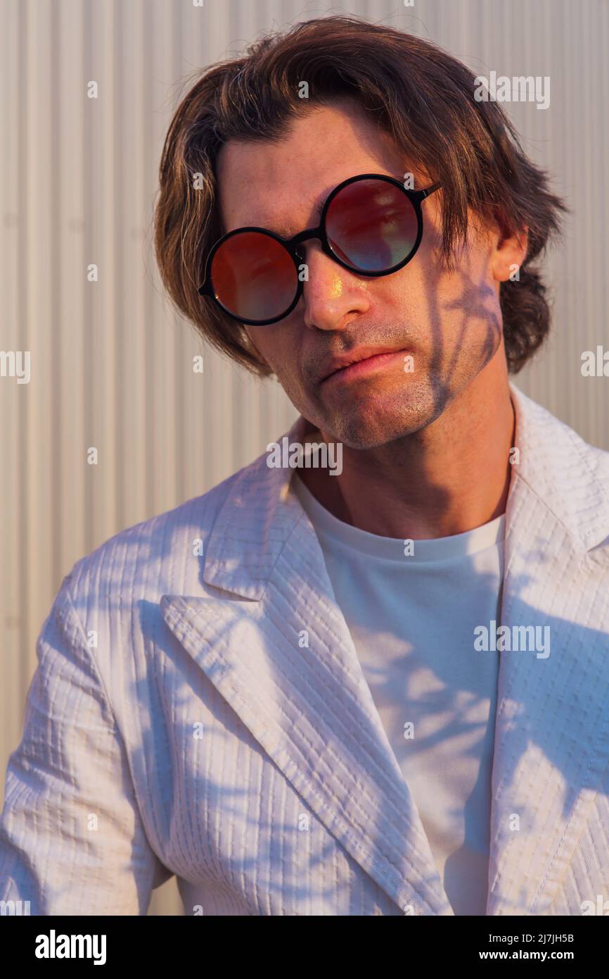 Primer plano retrato de un hombre guapo con gafas de sol redondas hippie  durante la puesta de sol Fotografía de stock - Alamy