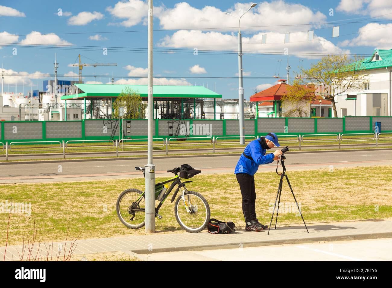 Fotógrafo callejero con cámara y trípode que captura paisajes de la ciudad. El fotógrafo de viaje captura una cámara sin espejo y con un lapso de tiempo en un trípode. Foto de stock