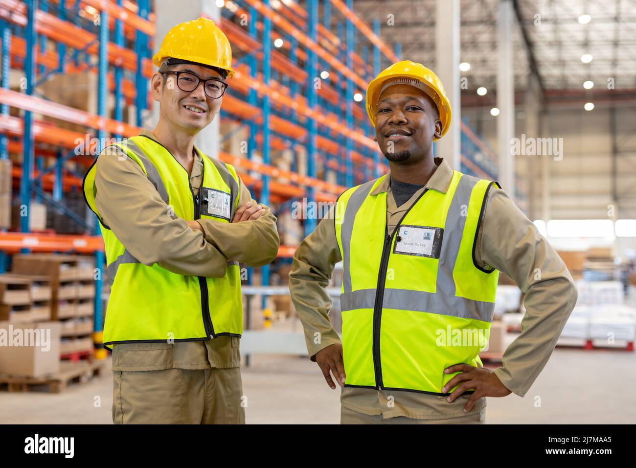 Retrato de sonrientes compañeros de trabajo masculinos multirraciales con ropa reflectante y sombreros Foto de stock