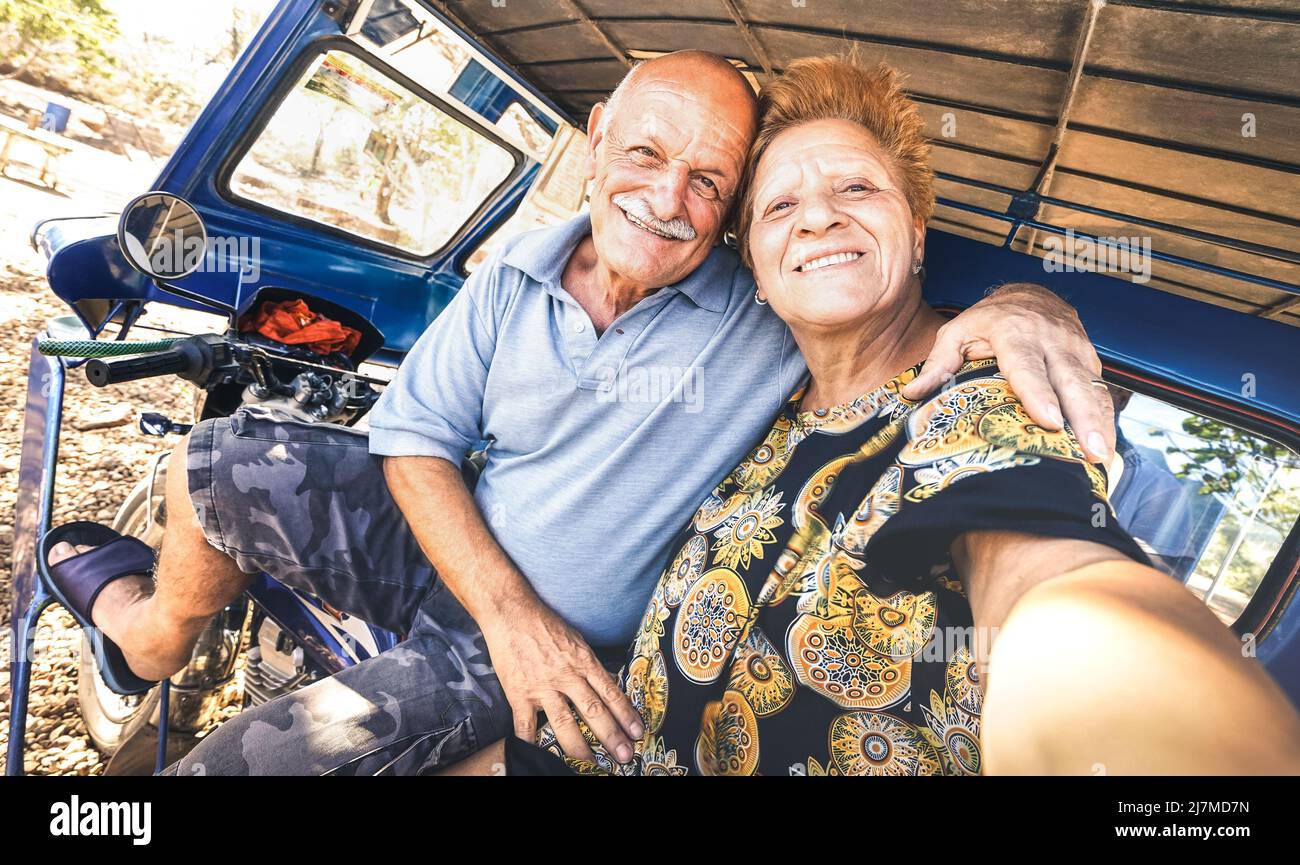Feliz pareja mayor tomando selfie en triciclo en Filipinas viaje - concepto de edad activa juguetona durante la jubilación - alegría diaria estilo de vida ingenio Foto de stock