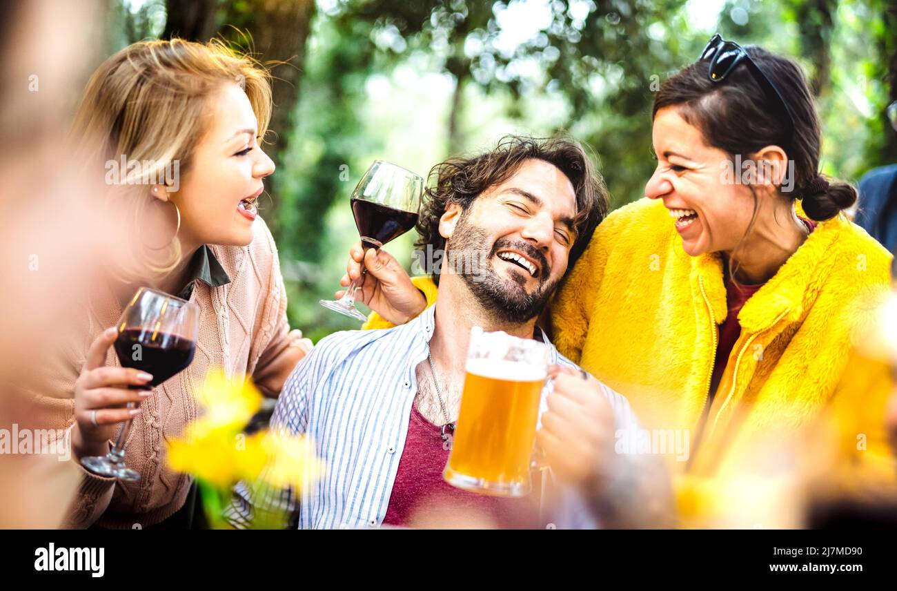 Jóvenes hombres y mujeres que se divierten al momento de beber vino y cerveza en la fiesta de jardín - Social reunión concepto de estilo de vida con la gente feliz disfrutar de la resaca Foto de stock