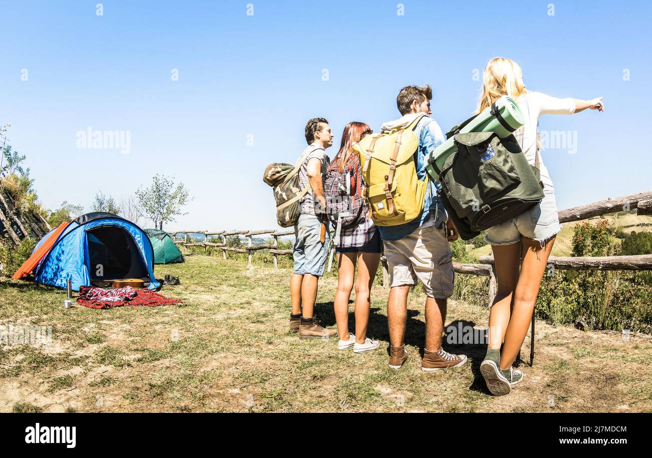 Grupo de amigos trekking en el campamento de viaje en las colinas italianas en el día soleado - Hikers con mochilas y palos caminando en contry - Wanderlust concepto de viaje Foto de stock