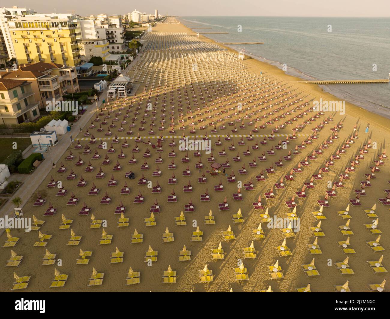 Playa dorada de Jesolo con hamacas y sombrillas en verano vista desde arriba durante el día soleado Foto de stock