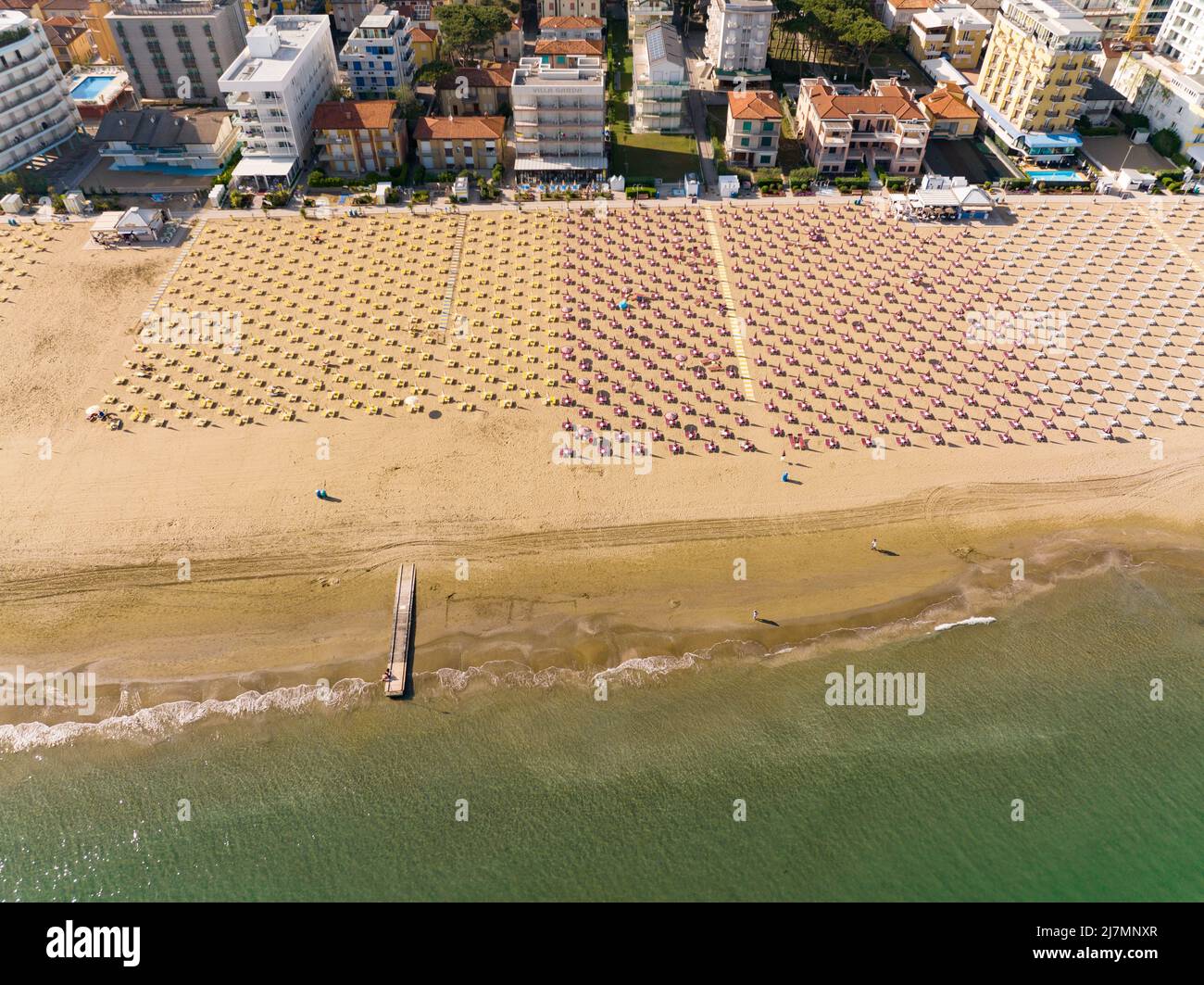 Playa Jesolo con hamacas, tumbonas y sombrillas en el lido marítimo visto desde arriba - vacaciones de verano en ciudades italianas Foto de stock