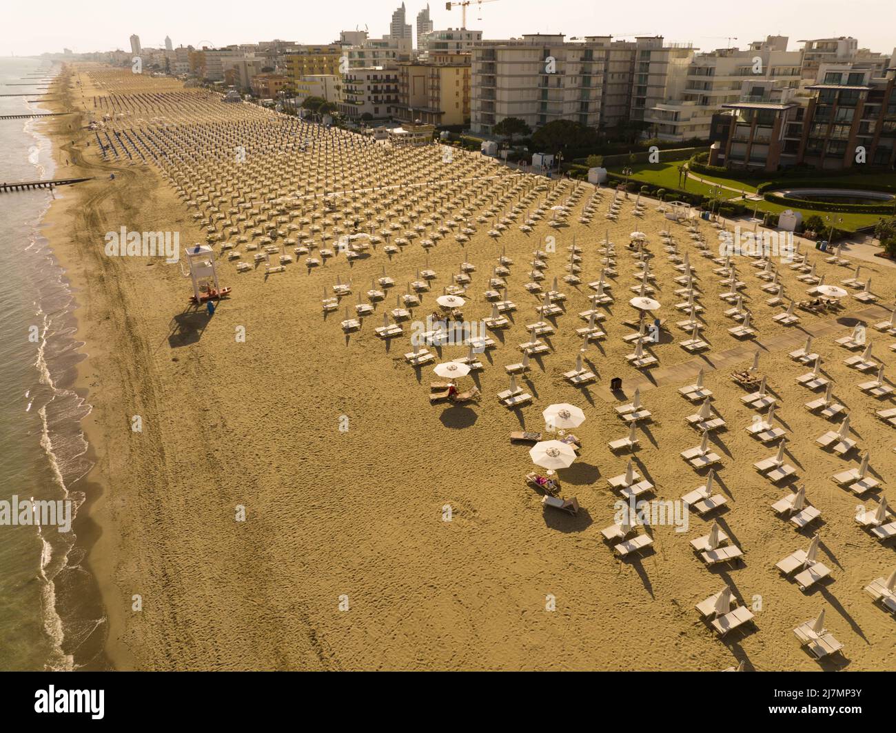 Jesolo playa dorada en la bahía con soladores y sombrillas de arriba - vacaciones de verano en Italia Foto de stock