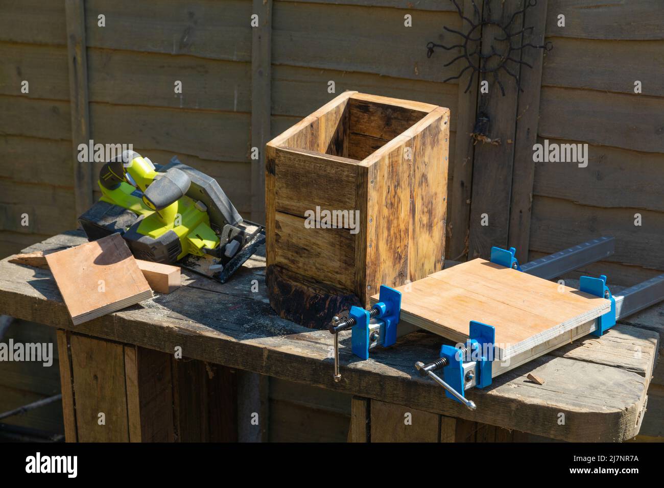 Fabricación de una caja de pájaros utilizando trozos de madera reciclados y de chatarra Foto de stock