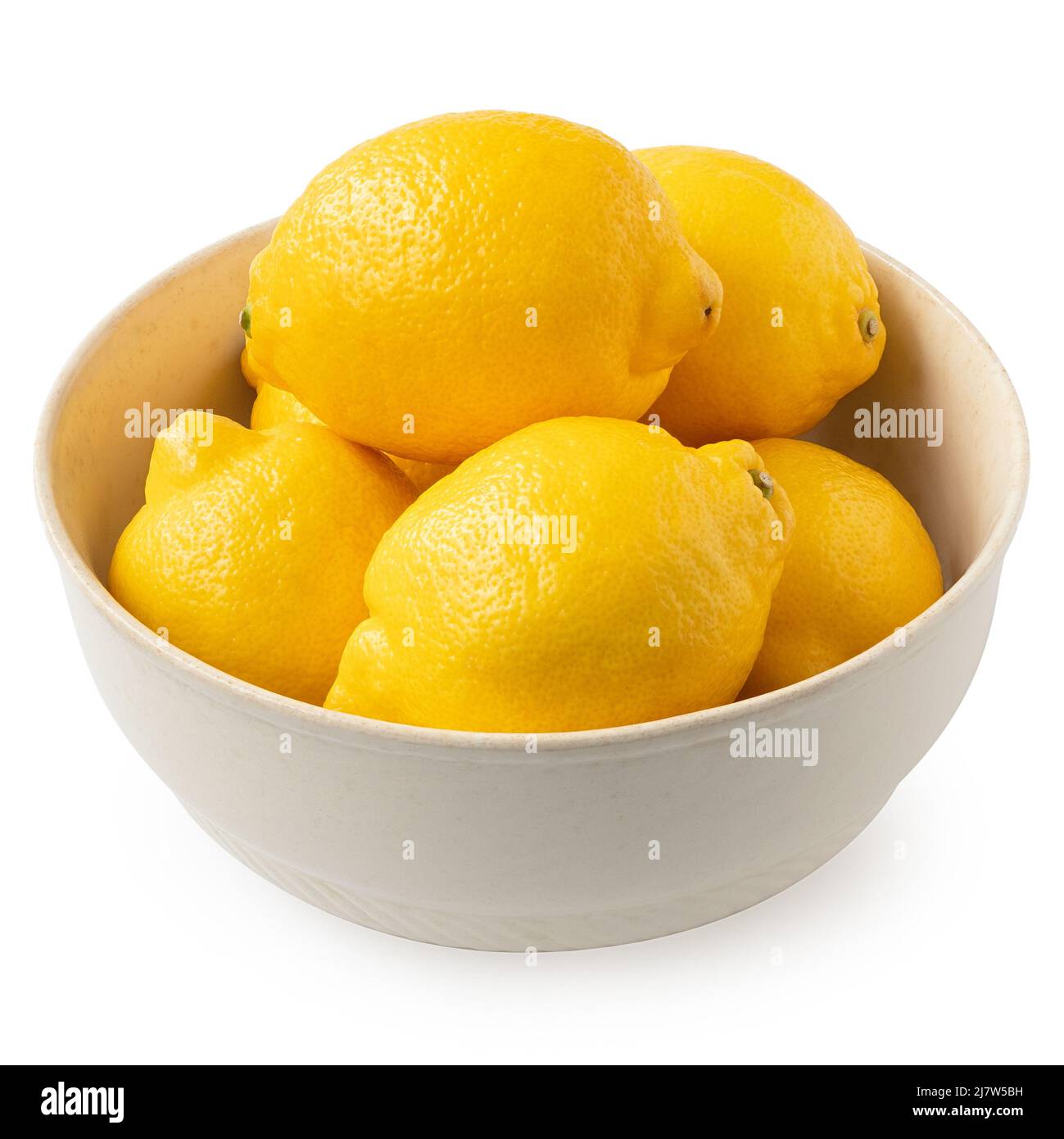 Limones frescos enteros en un tazón rústico claro aislado sobre blanco. Foto de stock