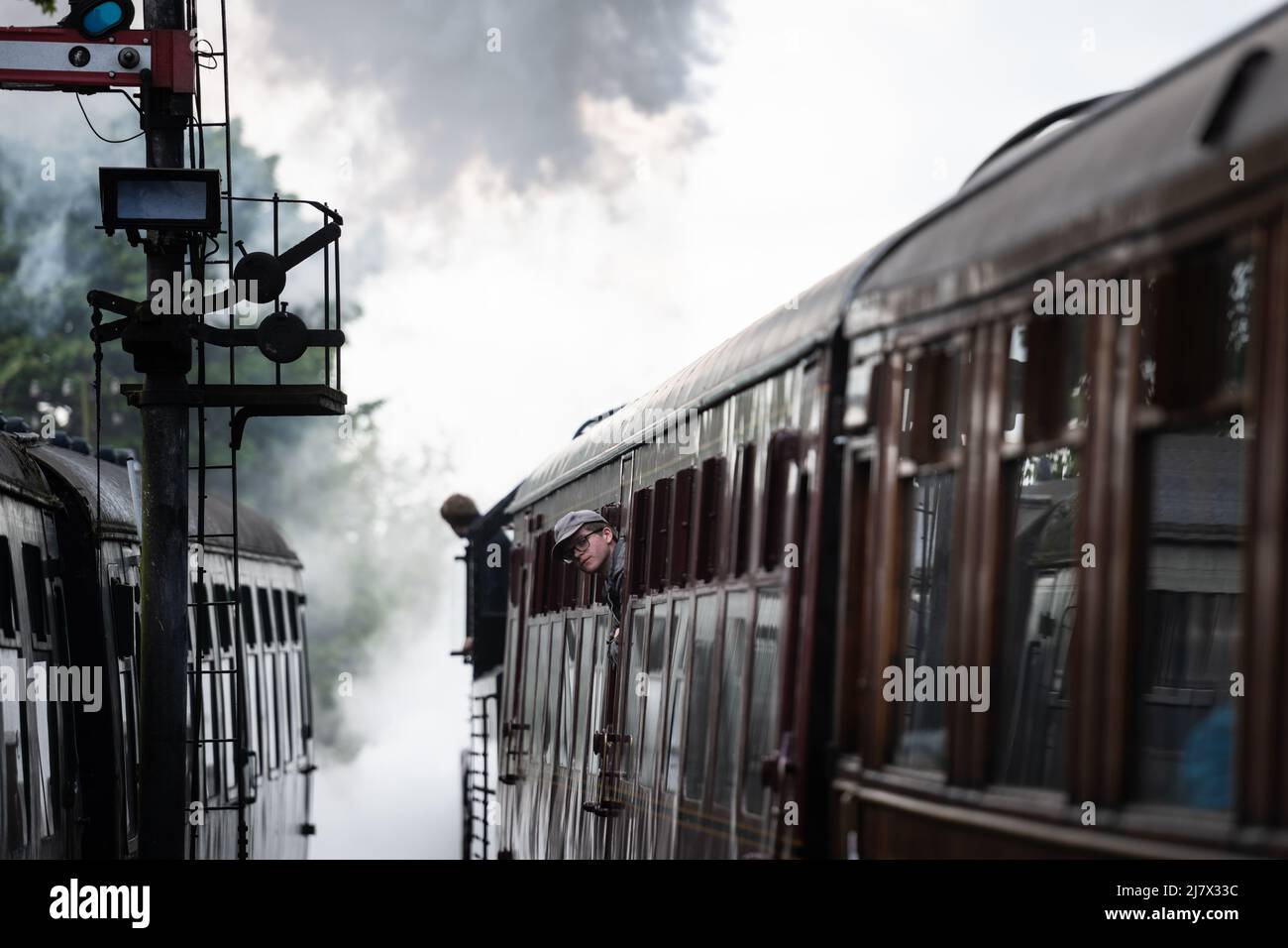 Estación de ferrocarril de Severn Valley Bridgnorth, Shropshire, Reino Unido. 7th de mayo de 2022. Un pasajero del tren de vapor mira por la ventana como el LMS Ivatt CLA Foto de stock
