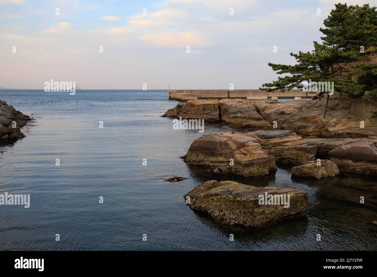 Rocas únicas erosionadas al lado del canal de agua con nubes antes de la puesta de sol en el fondo Foto de stock