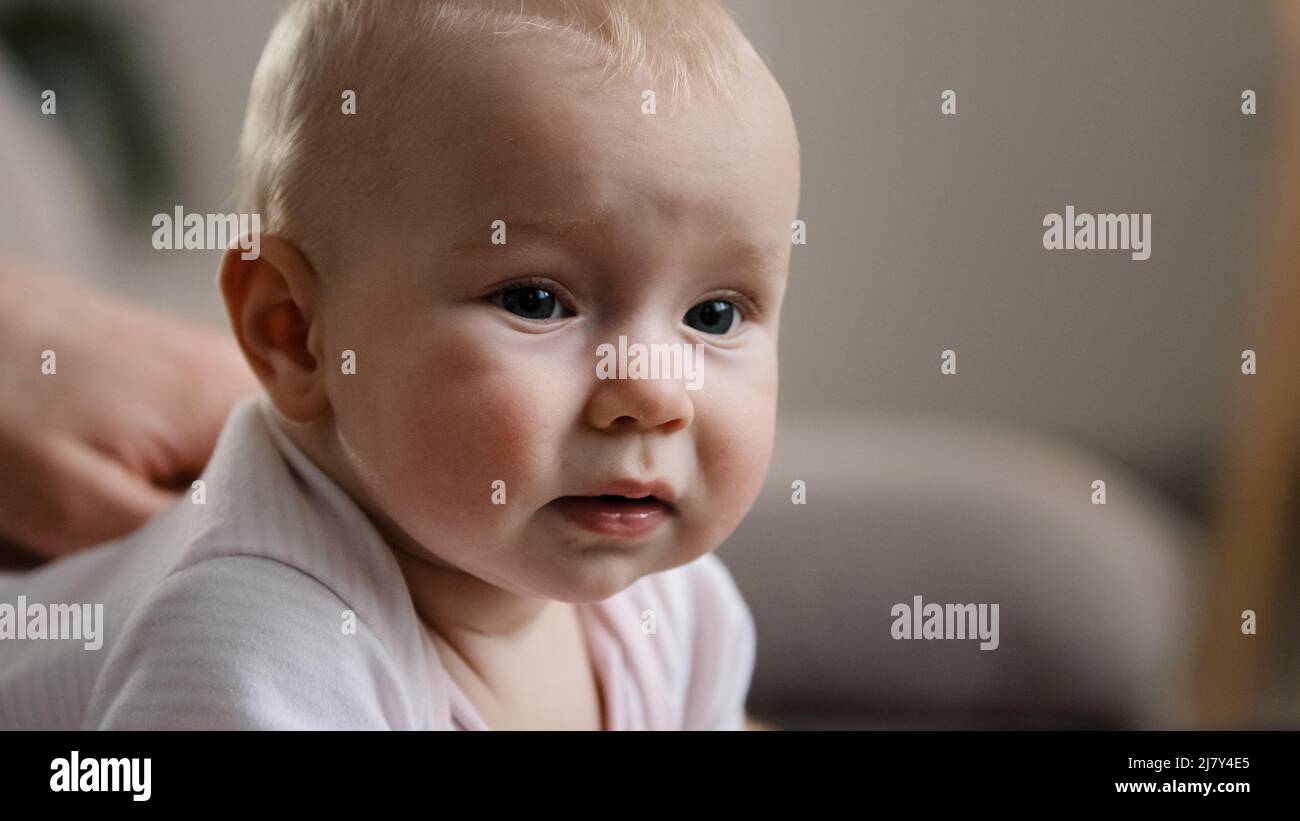 Primer plano niño emocional triste cara sonriente bebé expresión pequeña sonrisa con lindo reír tres meses de edad recién nacido cuidado y amor niño pequeño Foto de stock