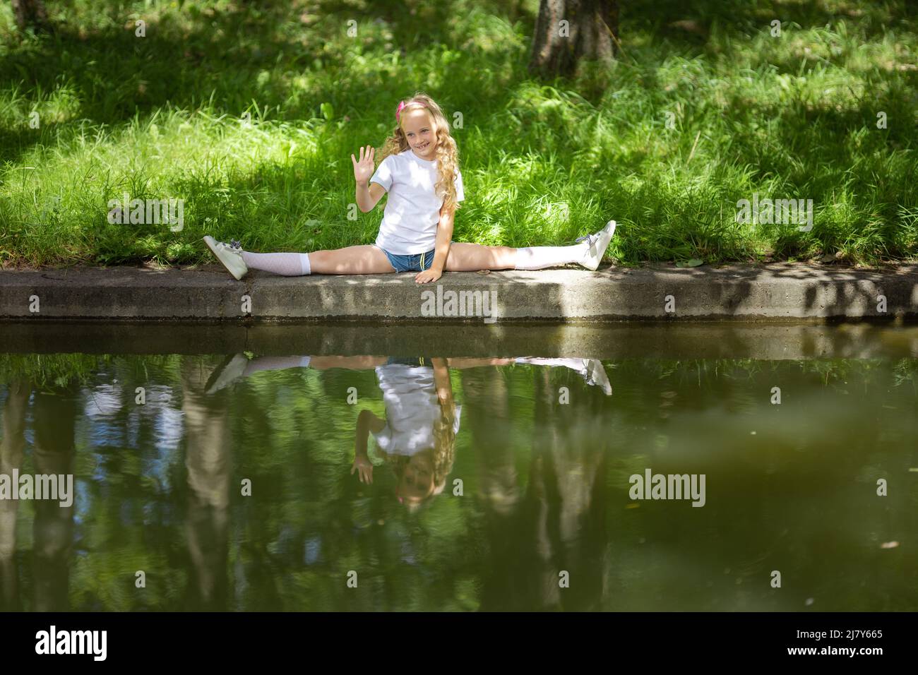 Niña bailando, saltando, haciendo acrobacias y posando, en un parque de ...