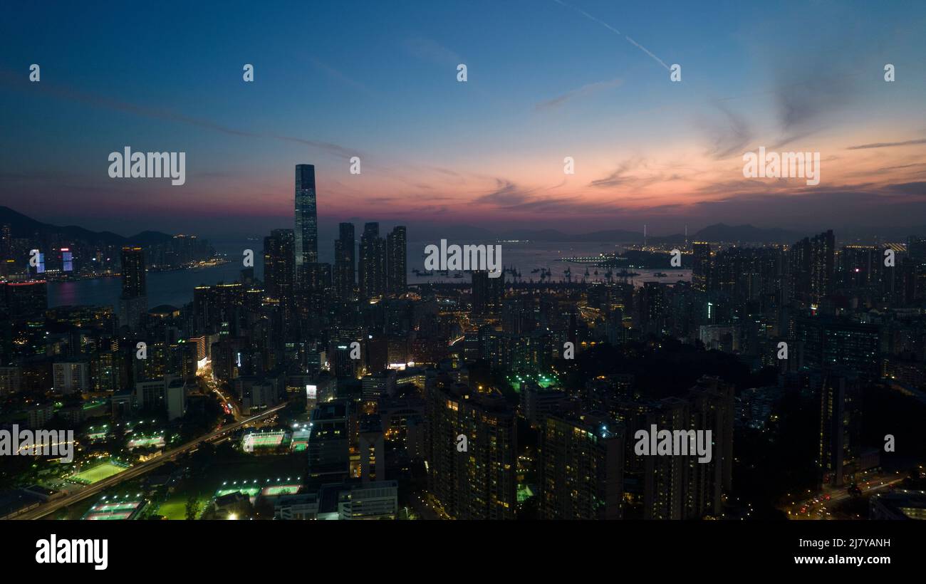 Paisaje urbano de Kowloon en Hong Kong, con el brillo posterior del cielo en el horizonte de la tierra Foto de stock