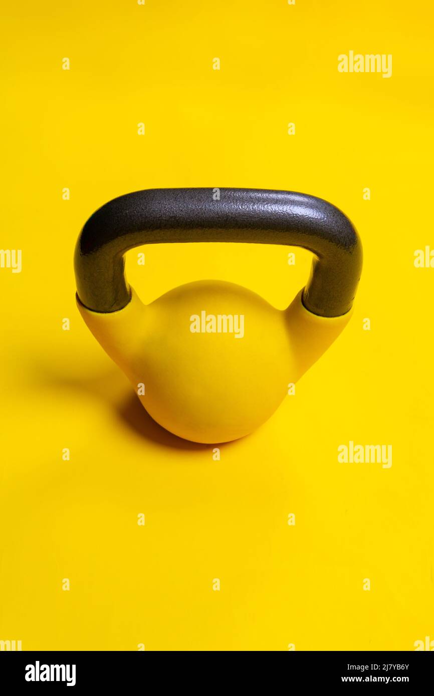 Amarillo azul espacio aislado kettlebell ackground fitness objeto culturismo, desde el peso del equipo para el bienestar y puño fuerte, fuerza de guante Foto de stock