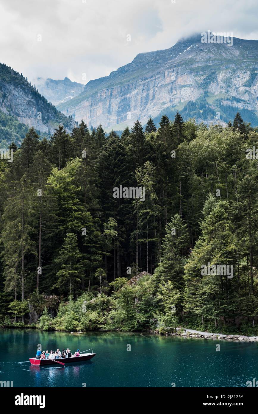 Blausee Suiza. 16. Julio 2018 Un romántico lago forestal en el valle de Kander, hermosa vista de Blausee un pequeño lago de aguas cristalinas, barco con la gente. Foto de stock