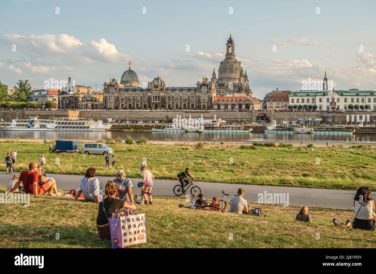 La gente local disfruta del atardecer en el río Elba, frente al horizonte de Dresden, Sajonia, Alemania Foto de stock