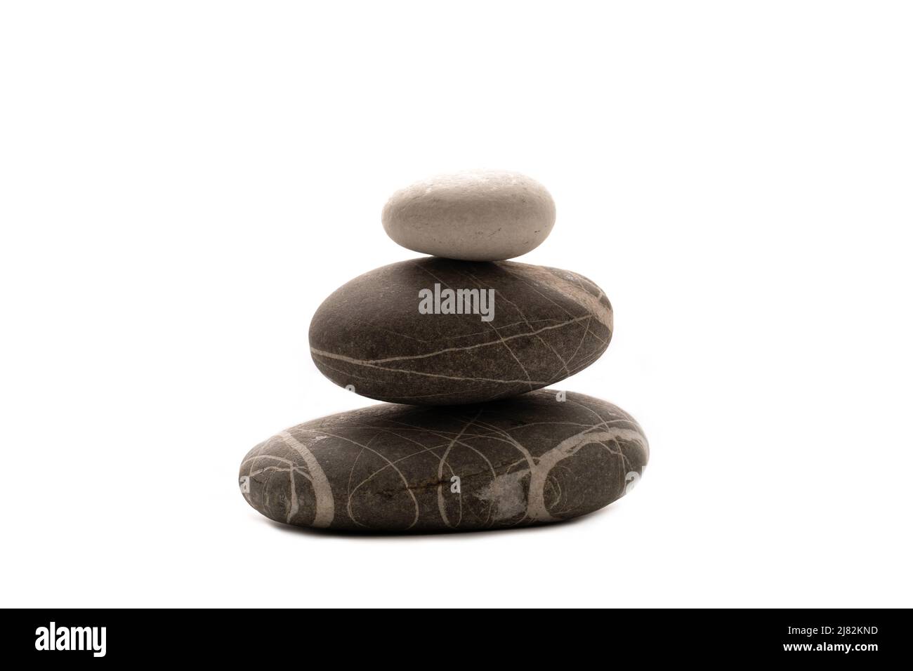Una pila de piedras sobre un fondo blanco aislado .Balance y armonía. Espacio de copia.Foto horizontal. Concepto de spa y atención sanitaria. Foto de stock
