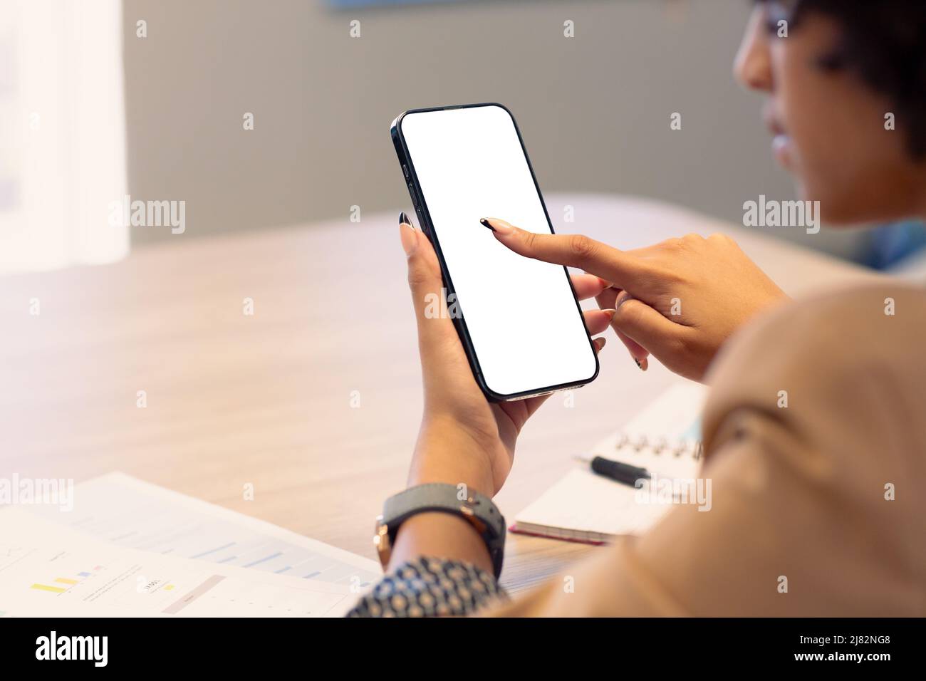 Mujer de negocios afroamericana que utiliza la pantalla táctil en el teléfono móvil con espacio de copia en pantalla en blanco Foto de stock