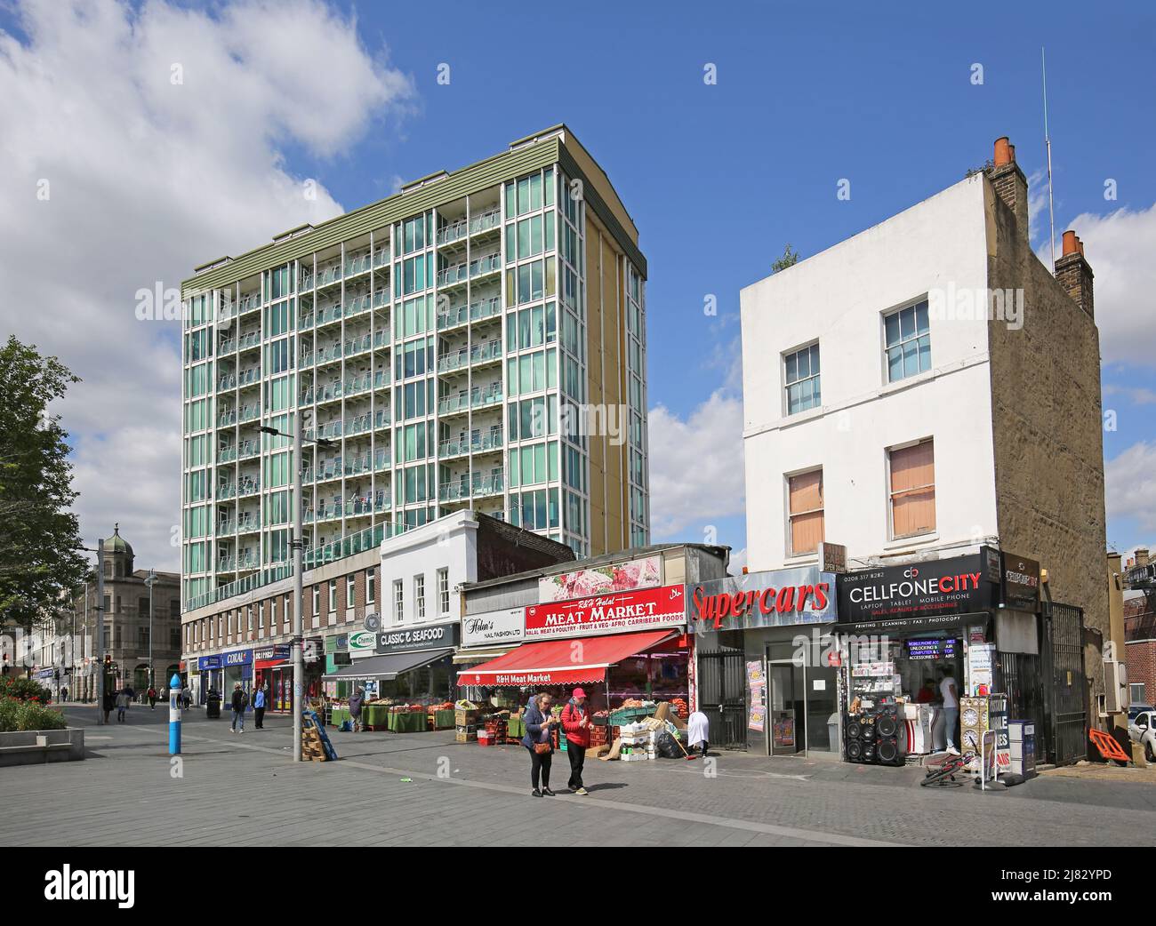 Tiendas en Greens End, General Gordon Square en Woolwich, al sureste de Londres. Bloque de apartamentos del consejo detrás. Foto de stock