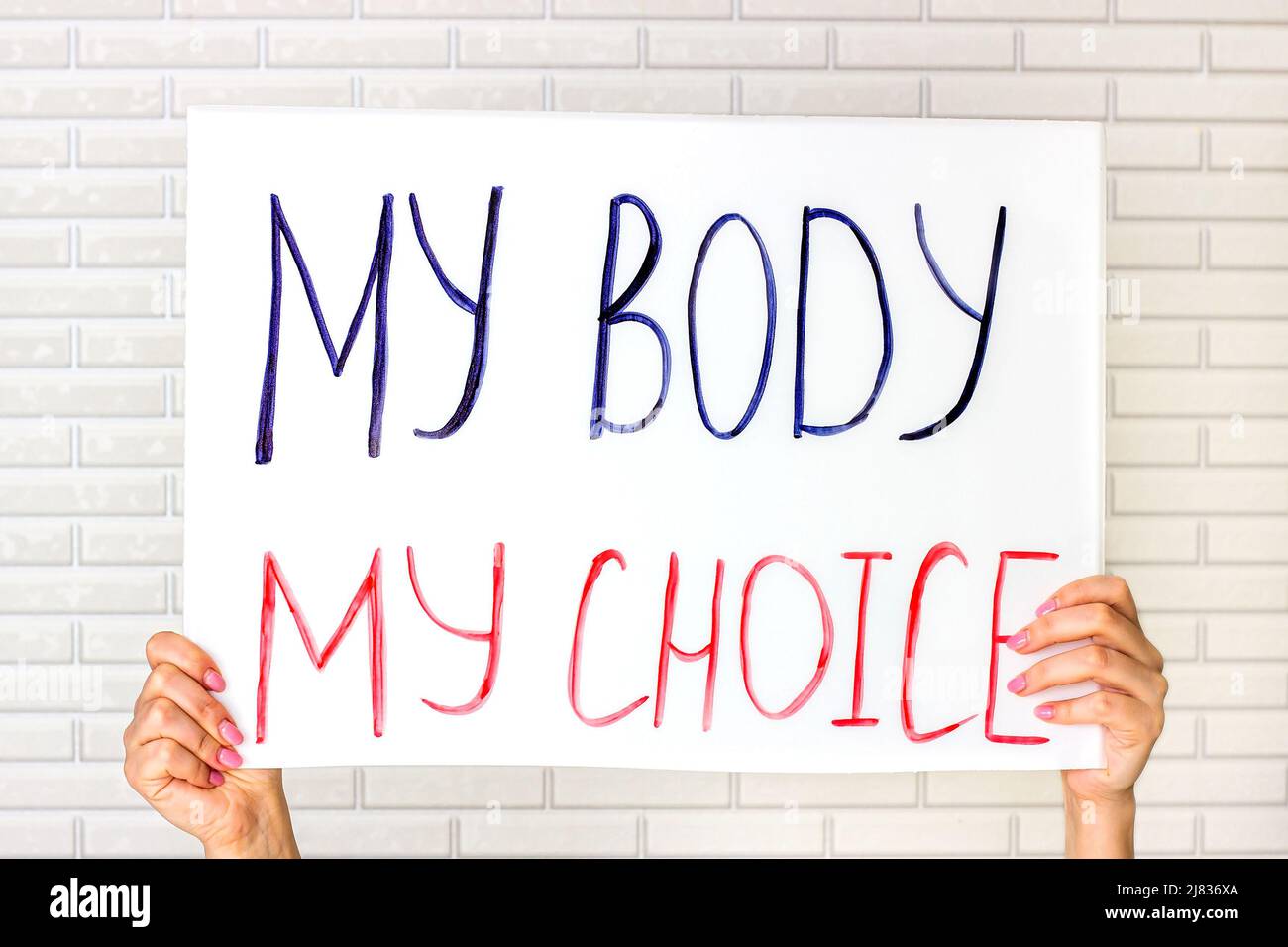 Mujer sosteniendo un cartel con mi cuerpo Mi texto de la opción. Las mujeres reproductivas y los derechos a favor del aborto protestan el concepto. Foto de stock