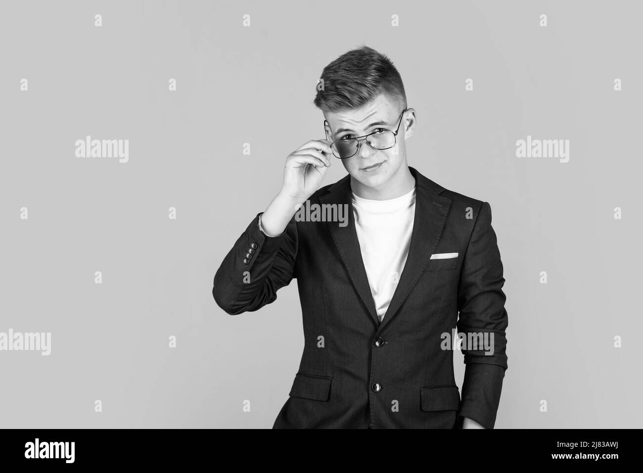 hombre de negocios de éxito. adolescente de moda. niño con chaqueta negra. niño seguro que lleva gafas. Foto de stock