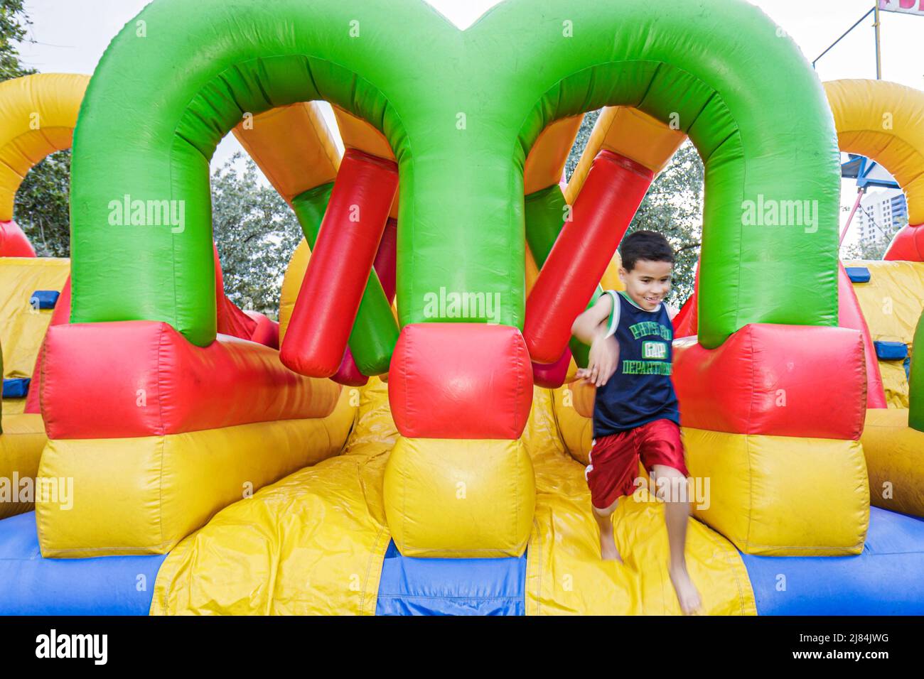 Miami Beach Florida, Flamingo Park, School's Out Fiesta, celebración, evento comunitario, curso de obstáculos inflables, niño infantil hispano jugando diversión Foto de stock