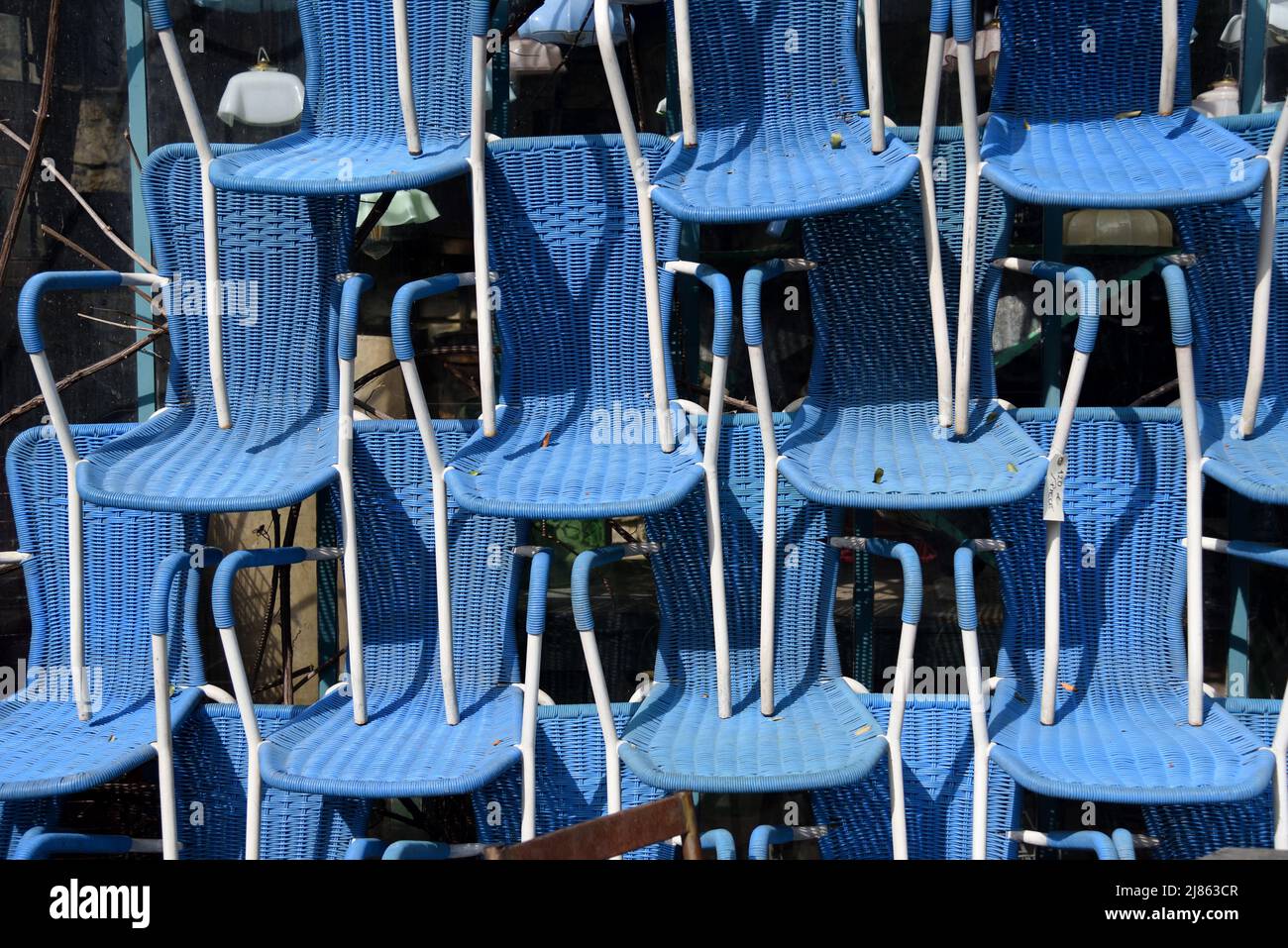 Exposición de sillas bistró de plástico azul o vintage apiladas en la tienda de antigüedades L'Isle-sur-la-Sorgue Vaucluse Provence Francia Foto de stock