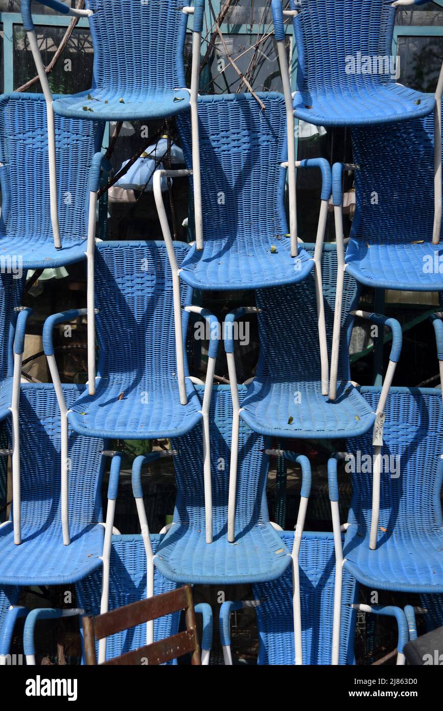 Exposición de sillas bistró de plástico azul o vintage apiladas en la tienda de antigüedades L'Isle-sur-la-Sorgue Vaucluse Provence Francia Foto de stock
