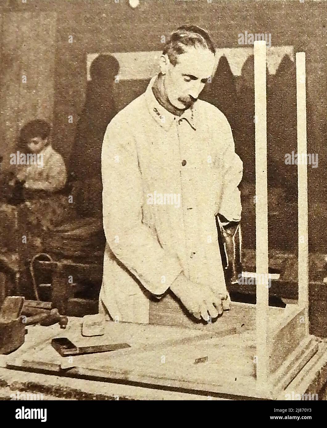 WWI - Rehabilitación de soldados británicos heridos en la Primera Guerra Mundial - Un hombre armado en el centro de rehabilitación de militares heridos en los talleres conmemorativos Lord Roberts, Fulham, .jpg - 2J8 Foto de stock