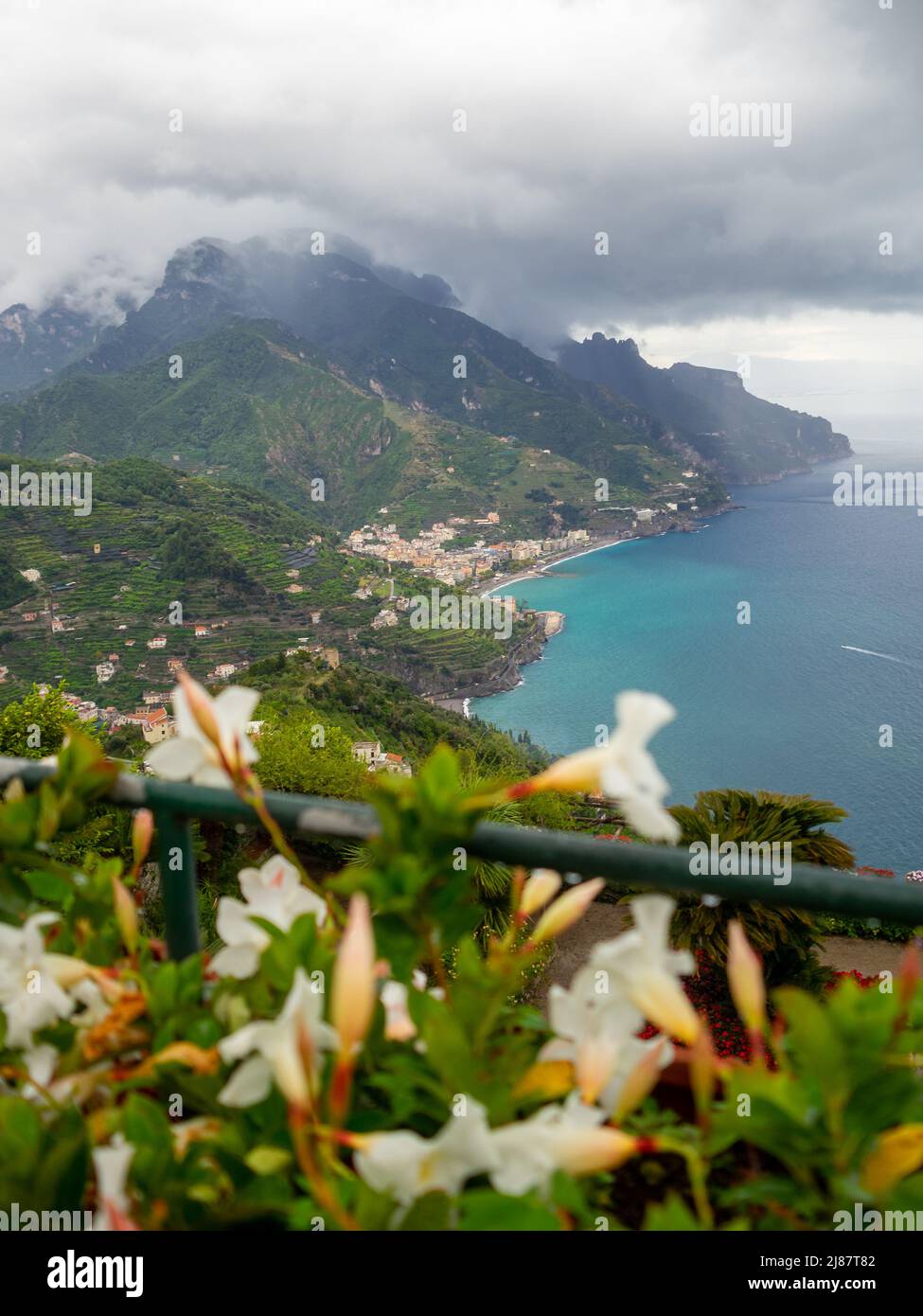 Flores blancas en los jardines de Villa Rufolo con la costa de Amalfi al fondo Foto de stock