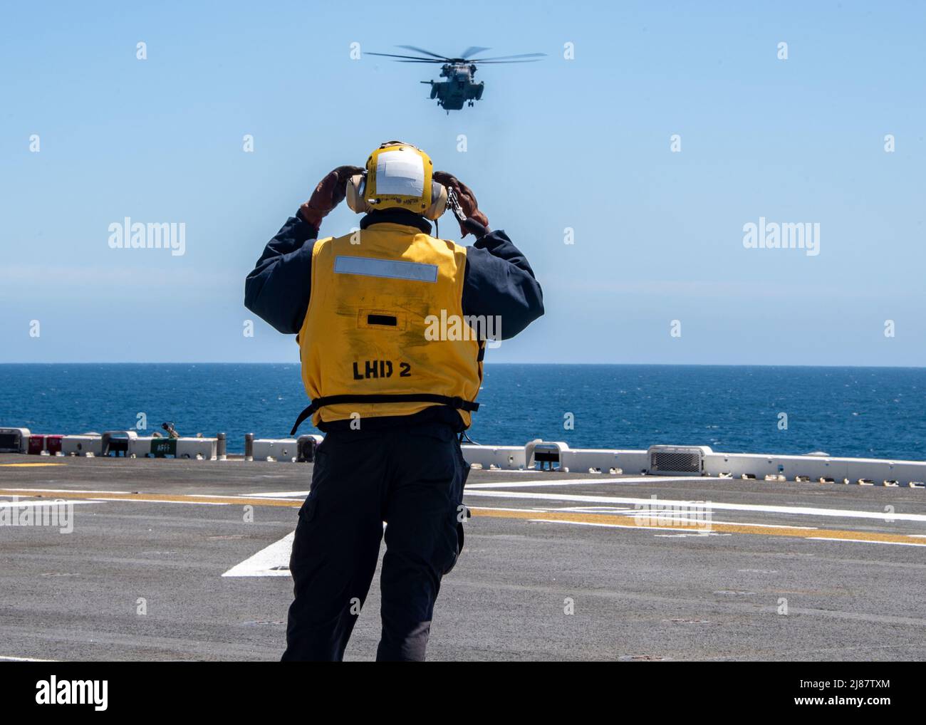 OCÉANO PACÍFICO (11 de mayo de 2022) Aviation Boatswain's Mate (Handling) Airman Corey Martin, un nativo de Jacksonville, Florida, envía señales a un estatlón marino CH-53D, adjunto al Escuadrón de Helicópteros Pesados Marinos (HMH) 462, a bordo del buque anfibio de asalto USS Essex (LHD 2), 11 de mayo de 2022. Essex está realizando operaciones de rutina en la flota 3rd de EE.UU. (EE.UU Foto de la Marina por el especialista en comunicación de masas Seaman Donita Burks) Foto de stock