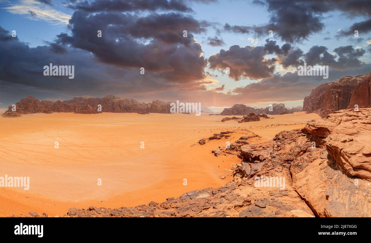 Arenas rojas, montañas, cielo dramático y paisaje marthiano panorama del desierto de Wadi Rum, Jordania Foto de stock