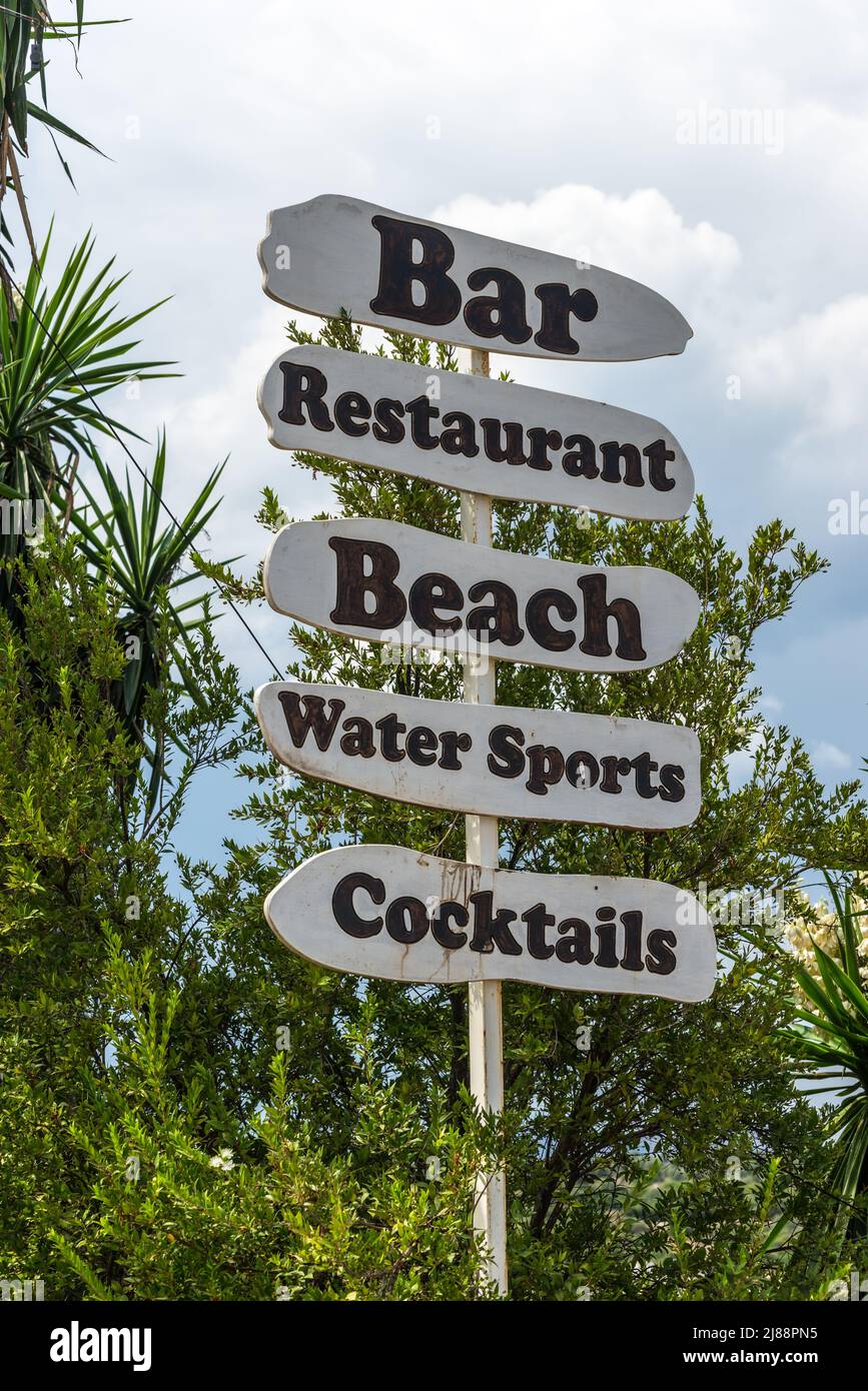 Ksamil, Albania - 9 de septiembre de 2021: Cartel con flecha al bar, restaurante, playa, deportes acuáticos, cócteles. Concepto de vacaciones de fondo. Foto de stock