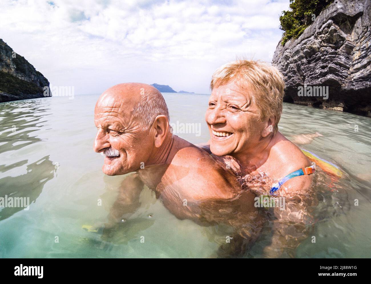 Pareja de veraneantes que tiene una verdadera diversión juguetona en la playa tropical en Tailandia - Snorkel tour en escenario exótico - Ancianos activos y concep de viaje Foto de stock