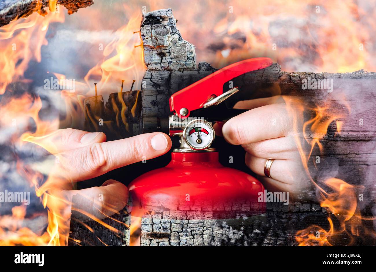 Vista de cerca del hombre trabajador que muestra el extintor de incendios rojo y lo controla. Concepto de servicio de mantenimiento. Composición fotográfica. Foto de stock