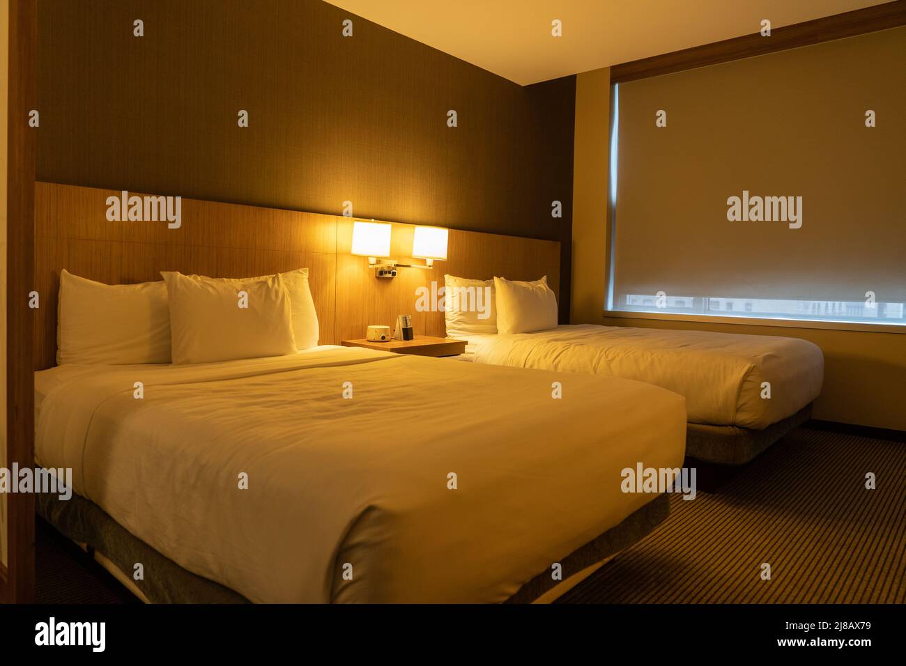 El interior del dormitorio del hotel tiene dos camas de matrimonio grandes Foto de stock