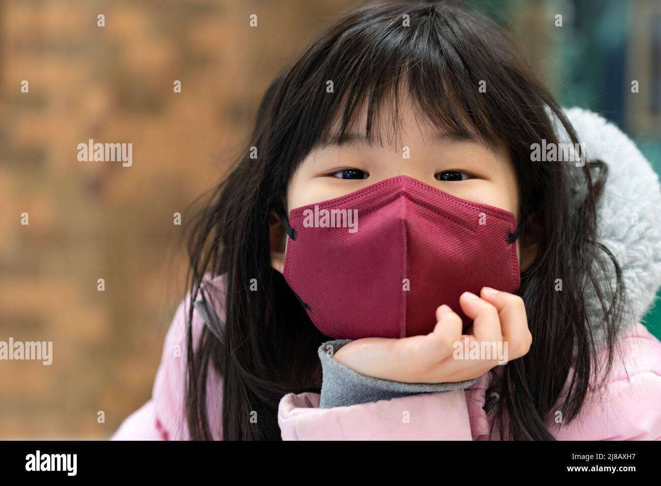 Niña pequeña asiática con máscara facial Foto de stock