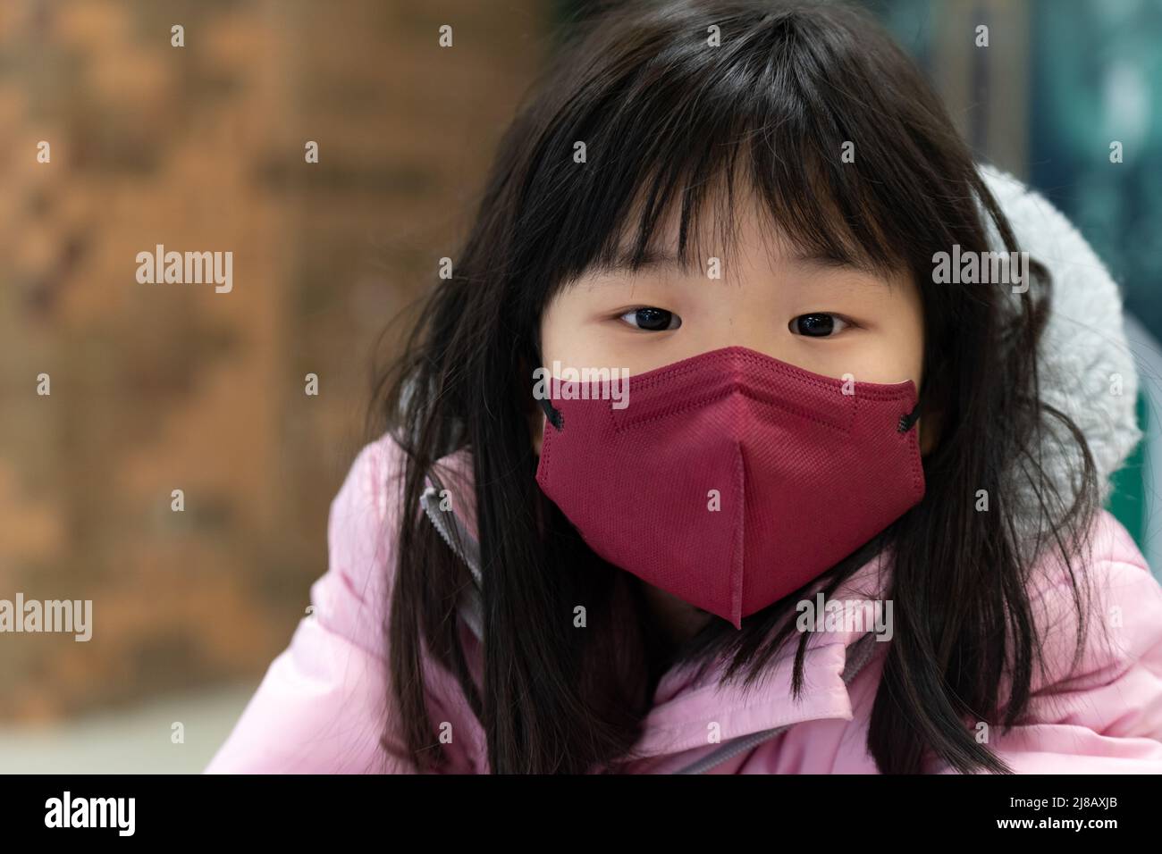 Niña pequeña asiática con máscara facial Foto de stock