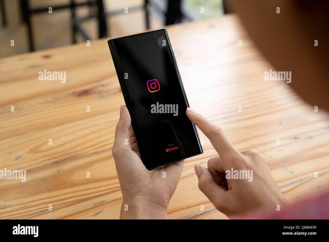 CHIANG MAI, TAILANDIA - MAYO de 14 2022: Una mujer tiene Samsung S22 ultra con aplicación Instagram de Meta en la pantalla. Instagram es más grande y más grande Foto de stock