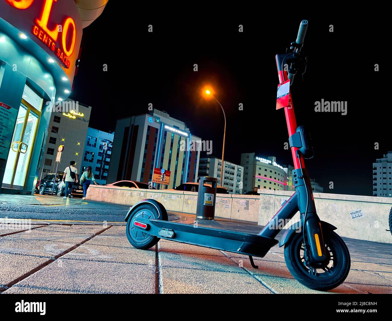 el scooter eléctrico está parado en la ciudad de la noche. Foto de stock