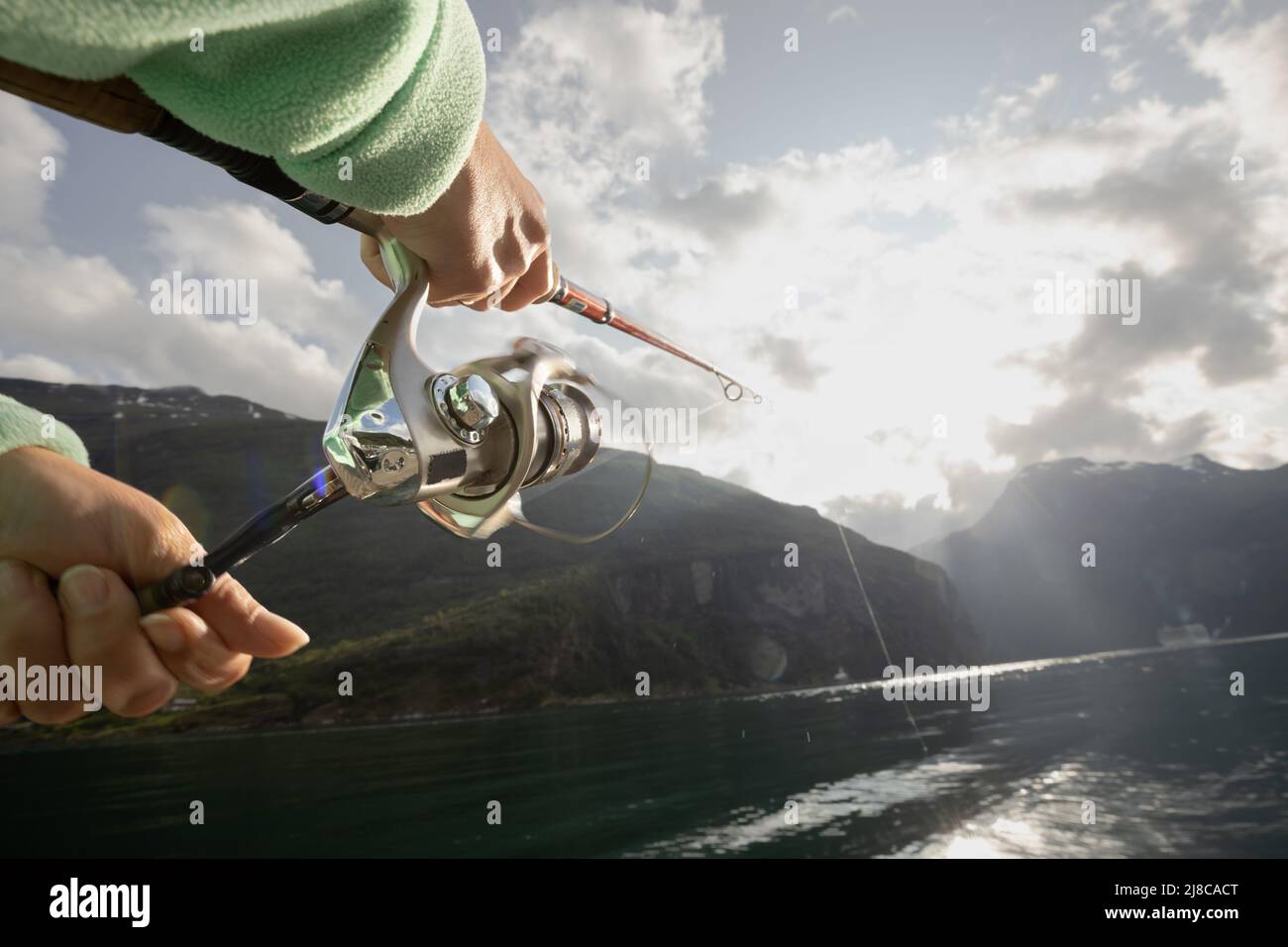 Mujer pesca en caña de pescar spinning en Noruega. La pesca en Noruega es una forma de abrazar el estilo de vida local. Innumerables lagos y ríos y una amplia Foto de stock